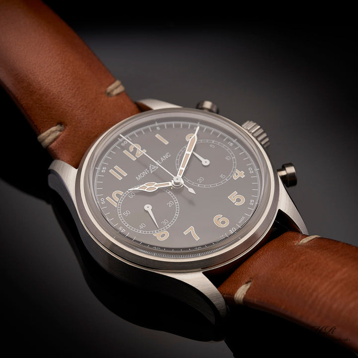 Armbanduhr mit schwarzem Ziffernblatt und braunem Lederarmband auf hochglanzschwarzer Oberfläche liegend