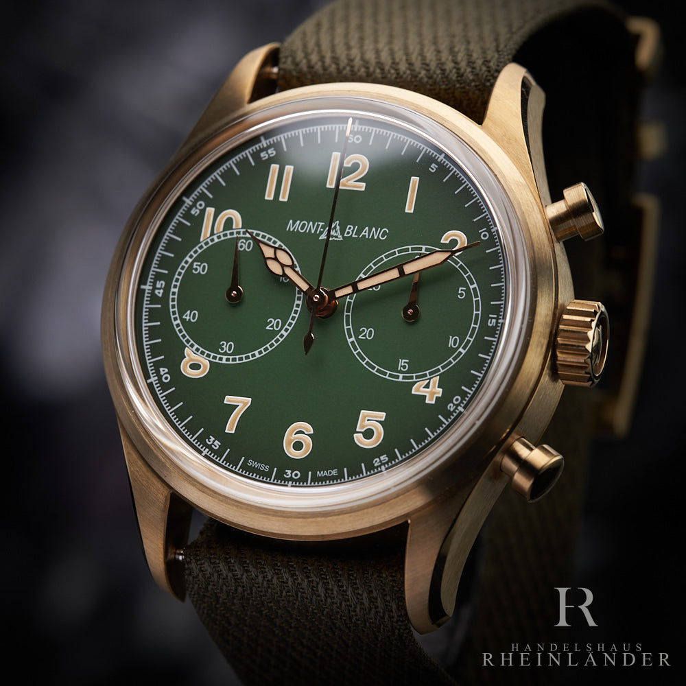 Bronze Armbanduhr mit grünem Ziffernblatt und Armband nah fotografiert vor grauem Hintergrund