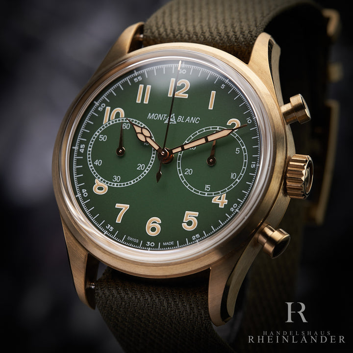 Bronze Armbanduhr mit grünem Ziffernblatt und Armband nah fotografiert vor grauem Hintergrund