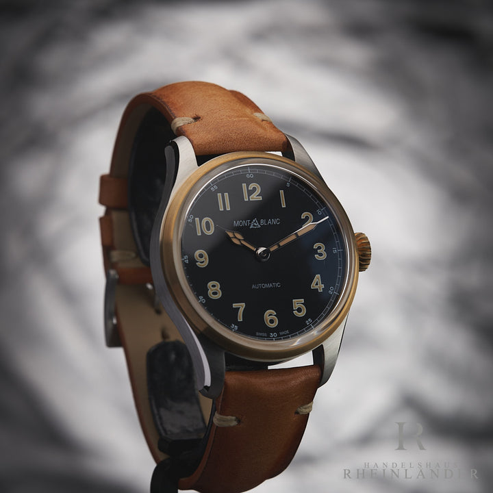 Armbanduhr mit schwarzem Ziffernblatt und hellbraunem Lederarmband leicht seitlich vor grauem Hintergrund fotografiert