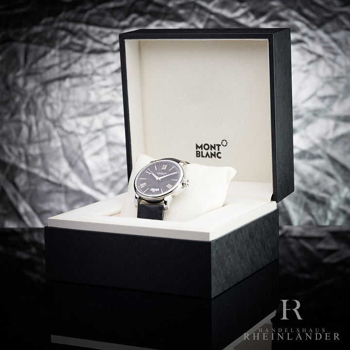Armbanduhr mit schwarzem Ziffernblatt und Lederarmband in Originalbox vor grauem Hintergrund