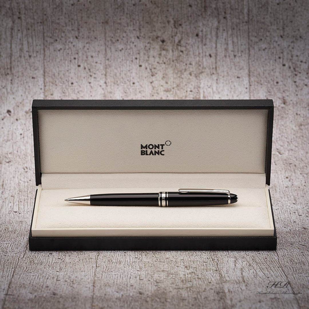 Schwarzer Drehbleistift in Originalbox liegend vor grauem Hintergrund in Holzoptik