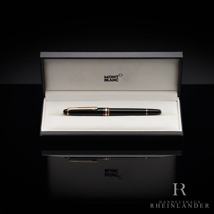 Schwarzer Rollerball mit goldenen Beschlägen in Originalbox liegend vor schwarzem Hintergrund