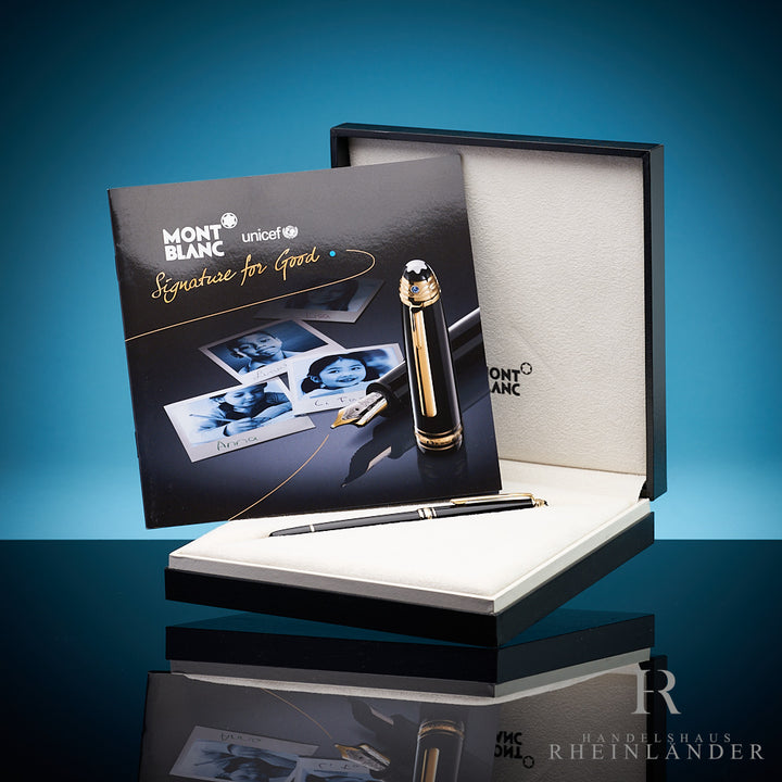 Schwarzer Rollerball liegt in Originalbox, darin aufgestellt das UNICEF-Serviceheft,  Hintergrund blau