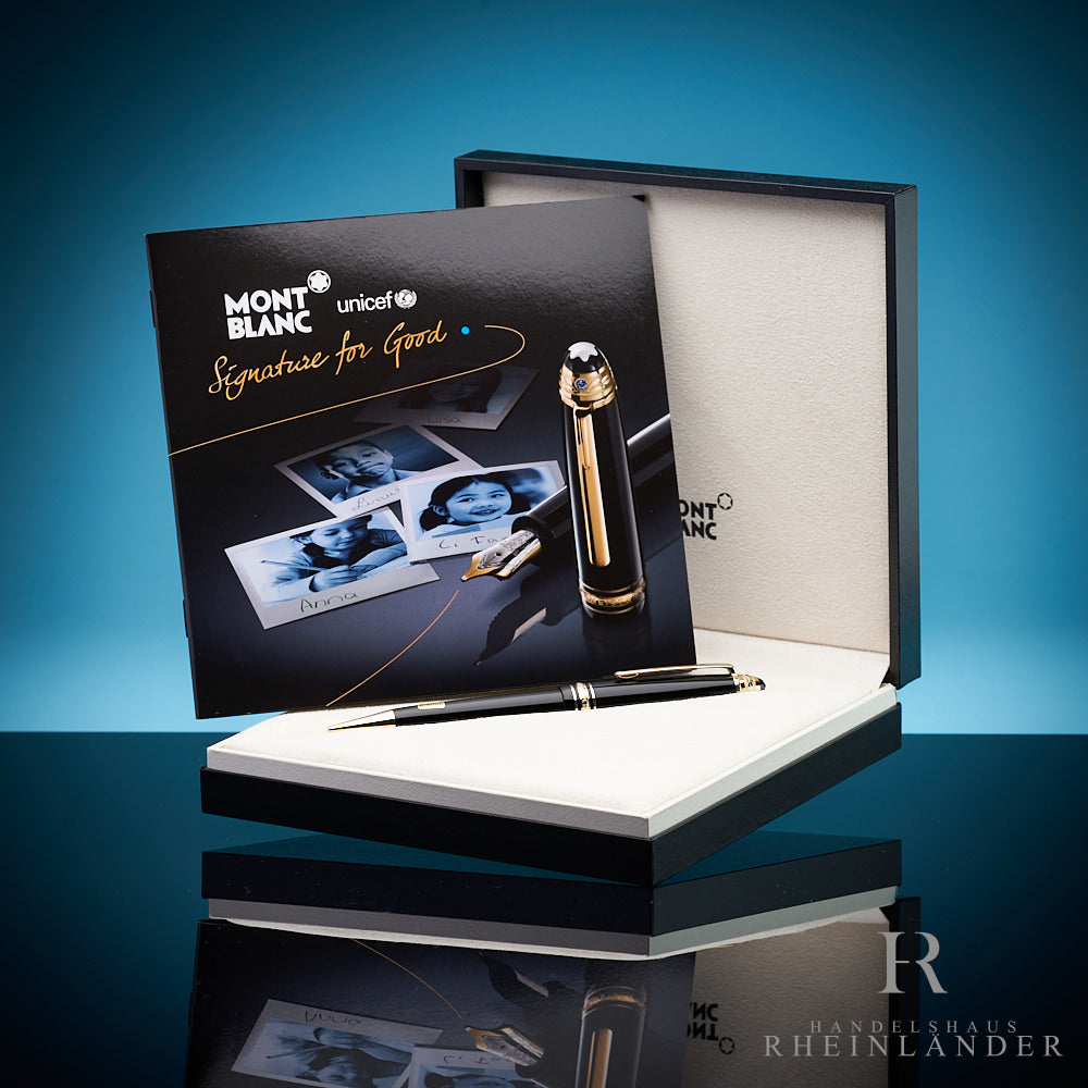 Schwarzer Stift liegt in Originalbox, darin aufgestellt das UNICEF-Serviceheft, Hintergrund blau