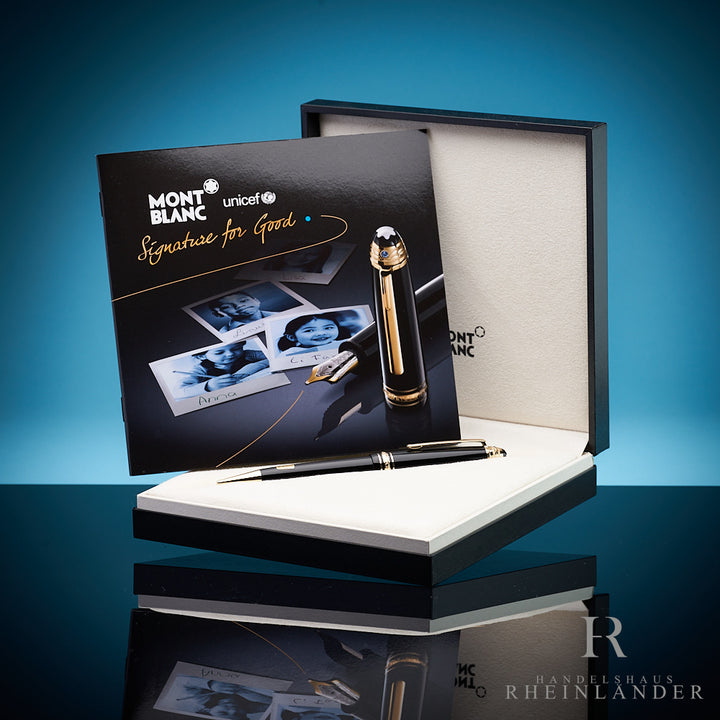 Schwarzer Stift liegt in Originalbox, darin aufgestellt das UNICEF-Serviceheft, Hintergrund blau