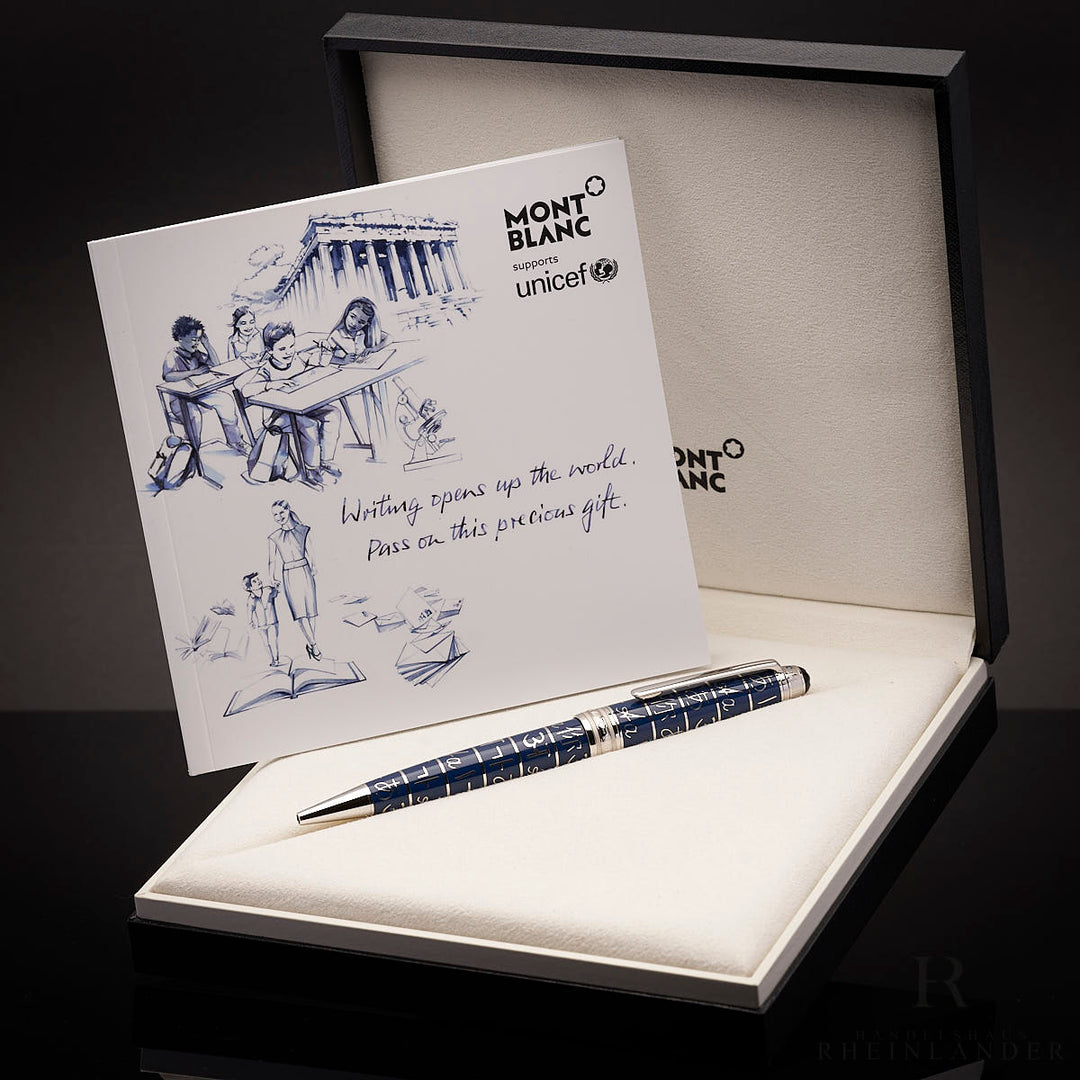 Silber-blau gemusterter Stift mit Serviceheft in offener Originalbox vor schwarzem Hintergrund