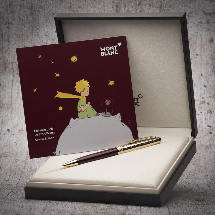 Burgunderfarbener Kugelschreiber mit goldener Kappe in Originalbox liegend, daneben Serviceheft mit Grafikdruck
