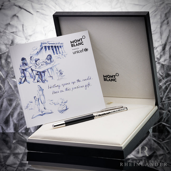 Schwarzer Rollerball mit silberner Kappe in Originalbox, darin aufgestellt das UNICEF-Serviceheft, Hintergrund silber