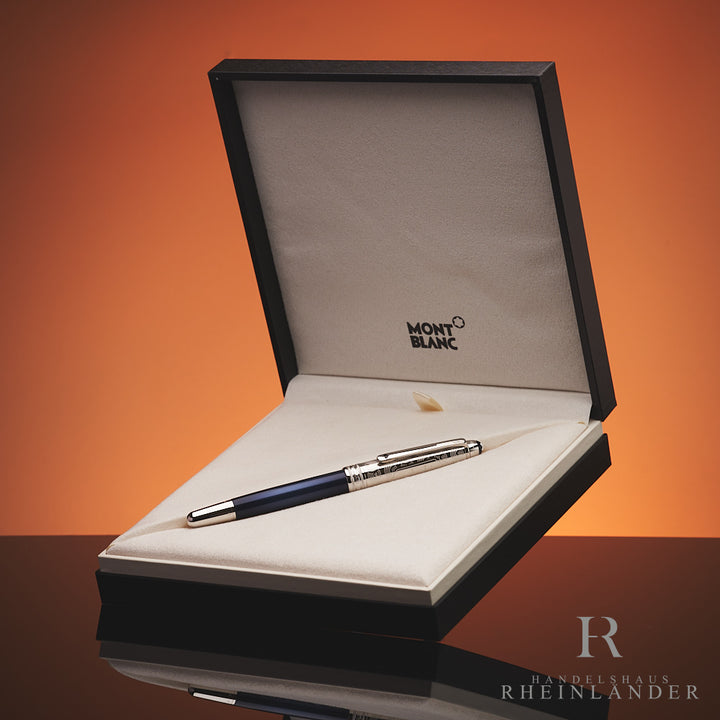 Dunkelblauer Rollerball mit silberner, gravierter Kappe in Originalbox vor orangem Hintergrund
