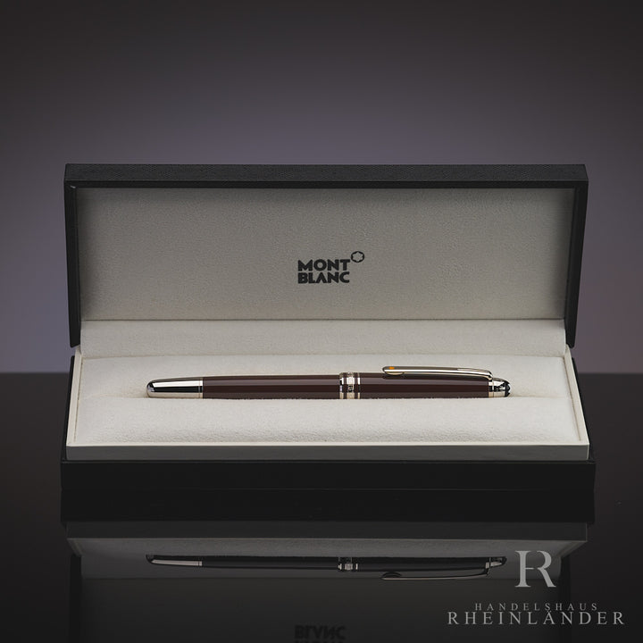 Dunkelbrauner Rollerball in offener Geschenkbox liegend vor grauem Hintergrund