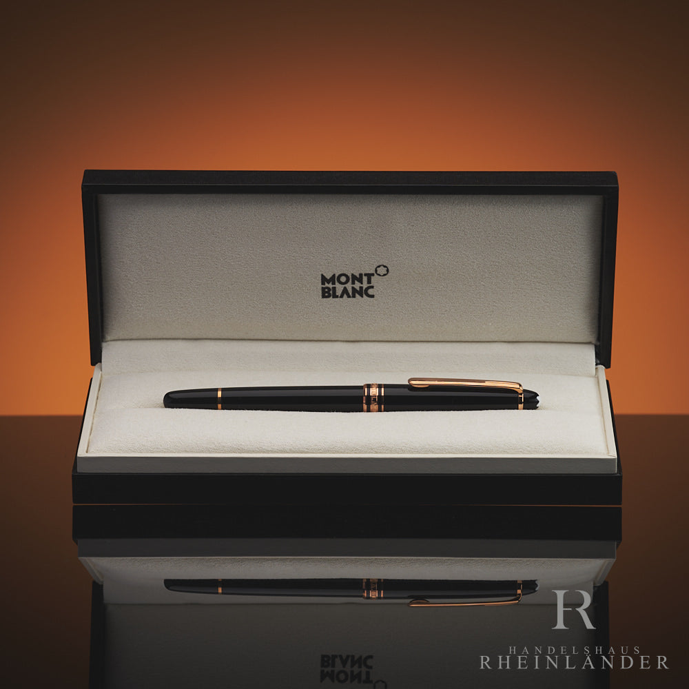 Schwarzer Rollerball mit rotgoldenen Beschlägen in offener Originalbox liegend vor orangebraunem Hintergrund