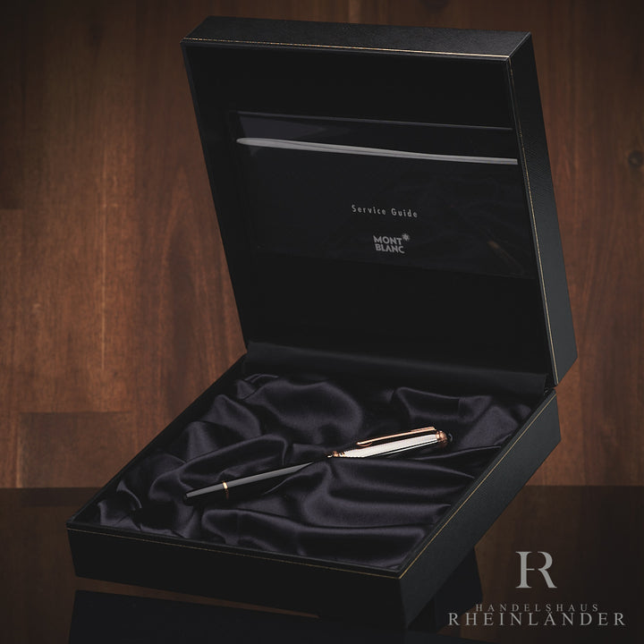 Schwarzer Rollerball mit silberner Kappe in offener Originalbox liegend vor Holzhintergrund