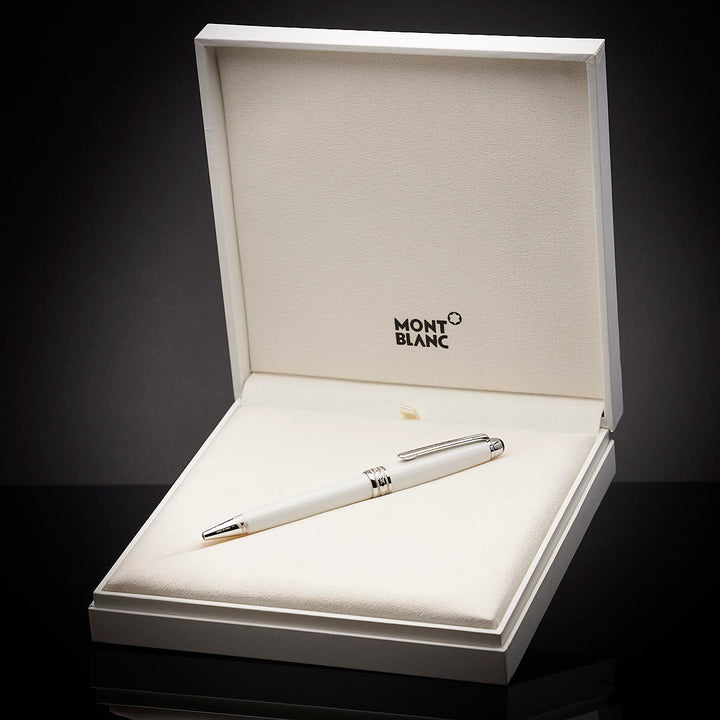 Weißer Kugelschreiber in weißer, offener Originalbox liegend vor dunkelgrauem Hintergrund