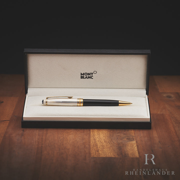 Schwarzer Bleistift mit silber-goldener Kappe liegt in offener Originalbox vor schwarzem Hintergrund, Untergrund Holz