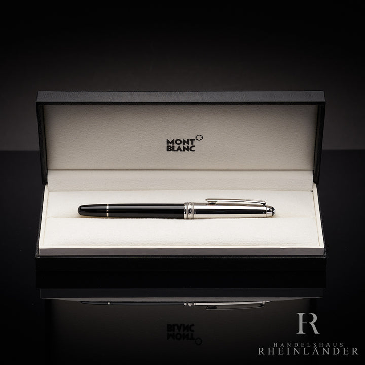 Schwarzer Rollerball mit silberner Kappe in Originalbox liegend vor schwarzem Hintergrund