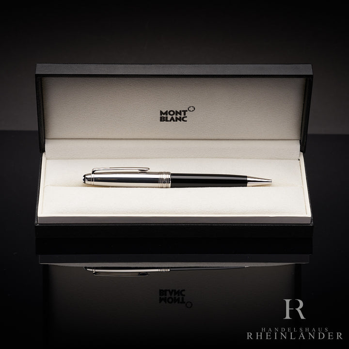 Schwarzer Kugelschreiber mit silberner Kappe in Originalbox liegend vor schwarzem Hintergrund