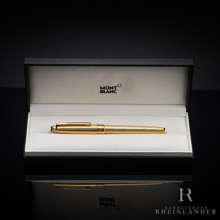Goldenes Schreibgerät in offener Originalbox liegend vor dunkelgrauem Hintergrund