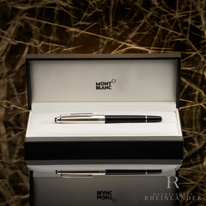 Schwarzer Füller mit silberner Kappe liegt in Originalbox. Untergrund spiegelnd, Hintergrund gold mit Knittereffekt.
