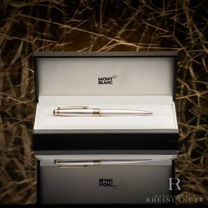 Silberner Kugelschreiber in offener Originalbox liegend vor goldenem Knitteroptik-Hintergrund