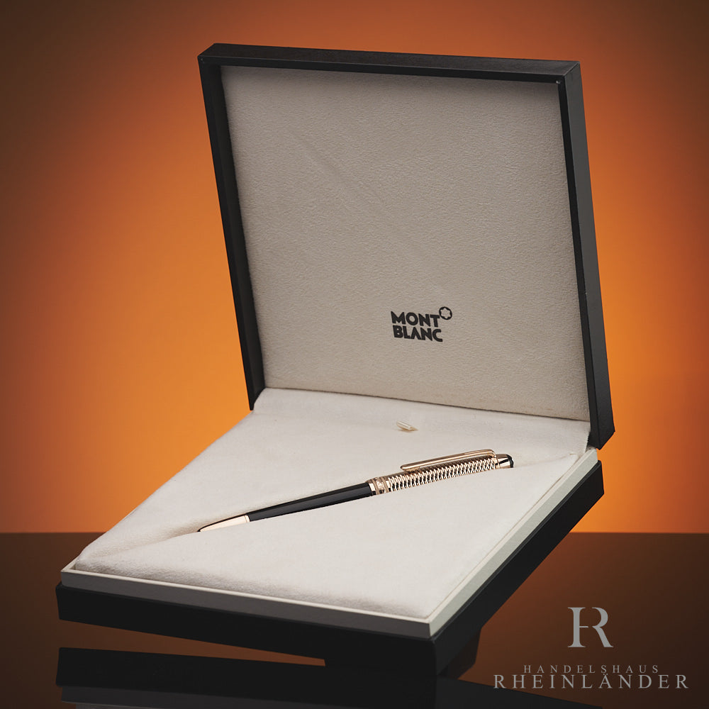 Schwarzer Füller mit goldener Kappe liegt in Originalbox vor orangenem Hintergrund