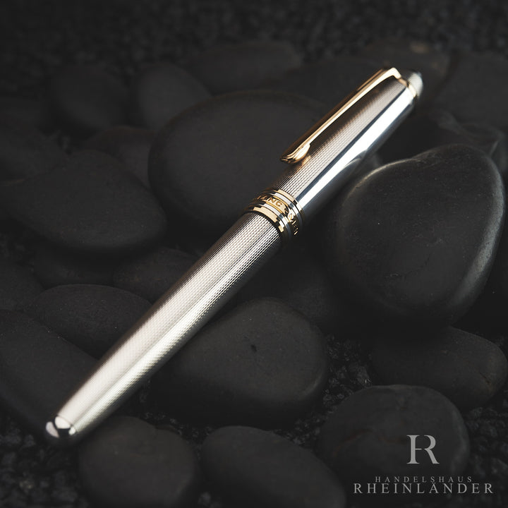 Silberner Rollerball von schräg oben auf dunklem Steinuntergrund fotografiert