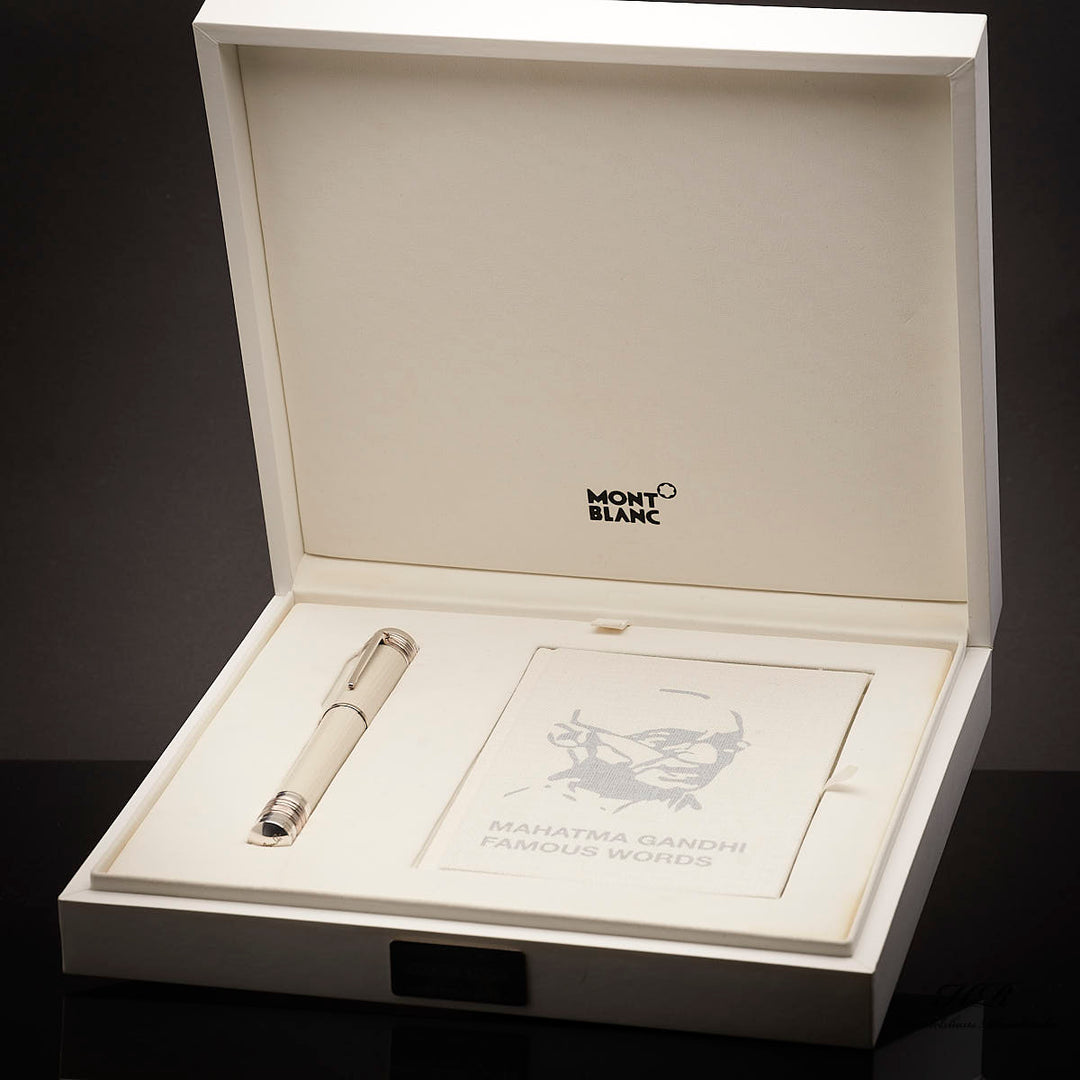 Weisser Füller zusammen mit Gandhi-Serviceguide in weisser, offener Originalbox liegend vor dunkelgrauem Hintergrund