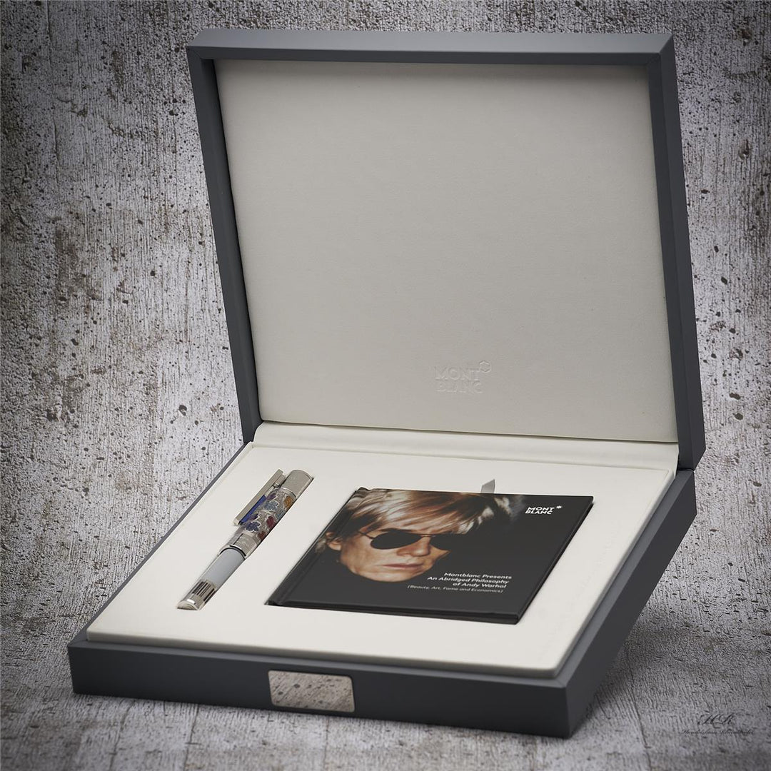 Schreibgerät mit Serviceheft in offener Editionsbox liegend vor grauem Hintergrund in Holzoptik fotografiert