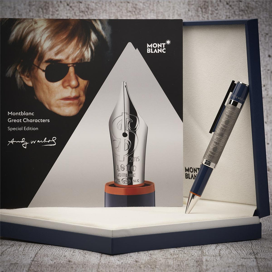 Schreibgerät und Warhol-Srviceheft in offener Editionsbox aufgestellt vor grauem Holzoptik-Hintergrund fotografiert