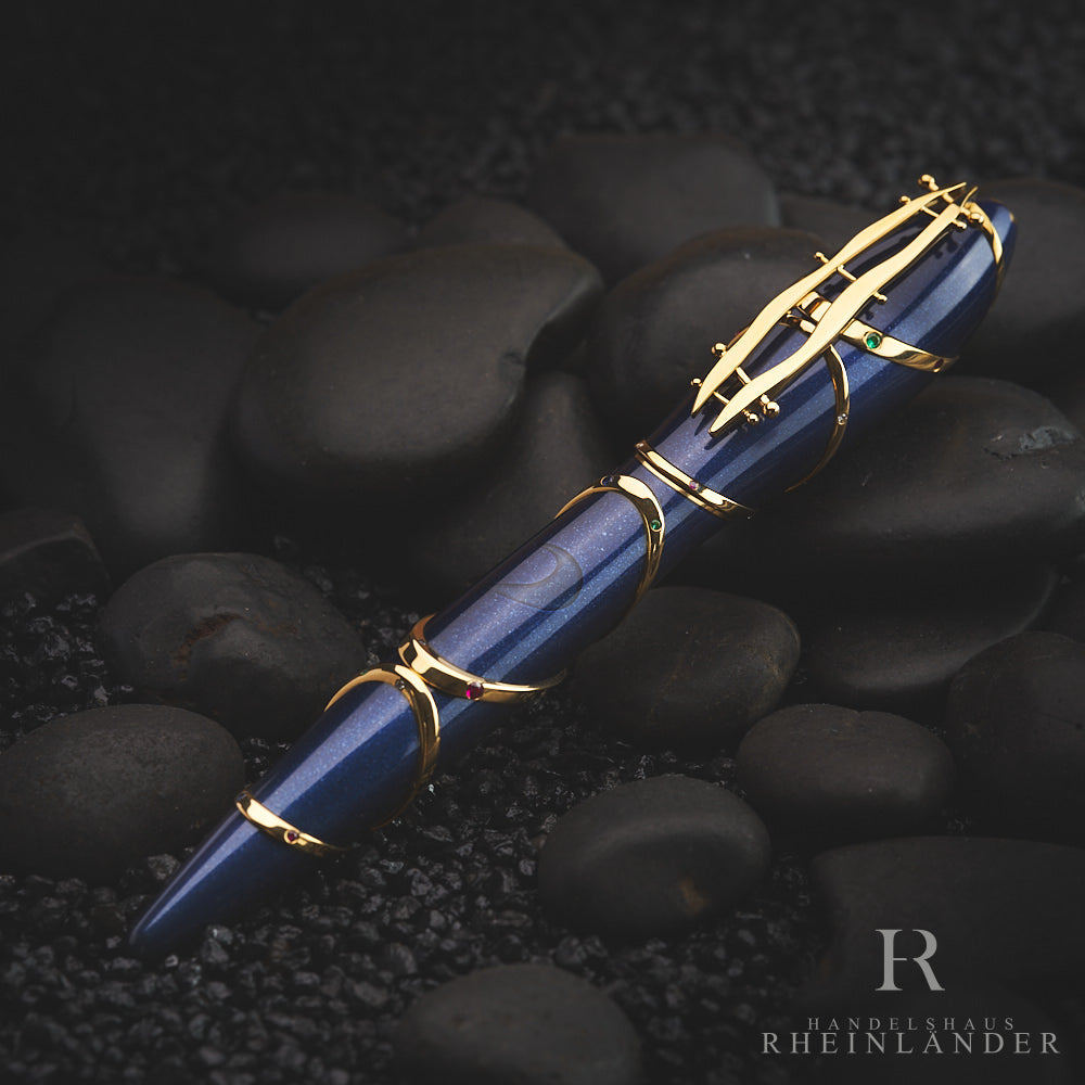 Tiefblauer Füller mit goldenen Details liegt auf dunkelgrauem Steingrund, von oben fotografiert