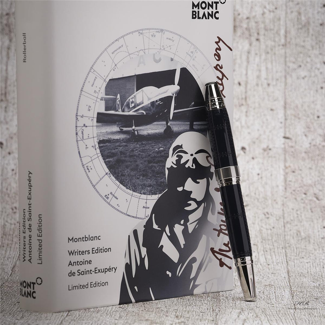 Dunkelblauer Montblanc Stift lehnt an Editions-Buchbox vor hellgrauem Hintergrund in Holzoptik