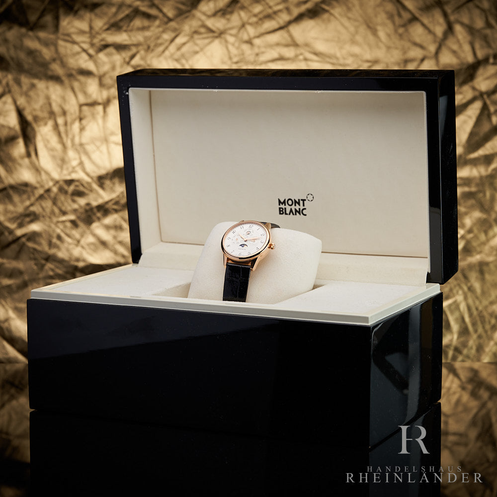 goldene Montblanc Uhr in Holzbox mit hellem Polster vor goldenem Hintergrund