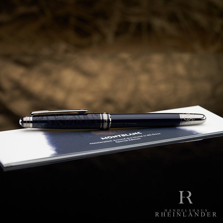 Dunkelblauer Rollerball von Montblanc mit silbernen Beschlägen vor hellbraunem Hintergrund auf Serviceguide liegend fotografiert