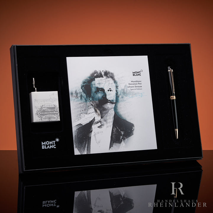Offene Geschenkbox, darin liegt schwarzer Kugelschreiber von Montblanc zusammen mit Serviceguide mit Portrait von Johann Strauss