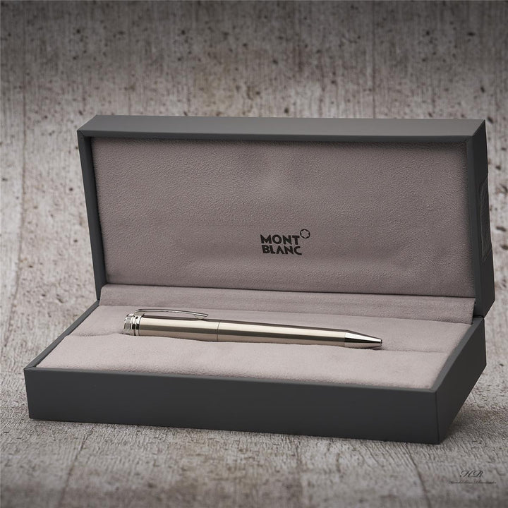 Schlichter, silberner Rollerball in geöffneter, grauer Montblanc-Box, vor Holzoptik-Hintergrund fotografiert