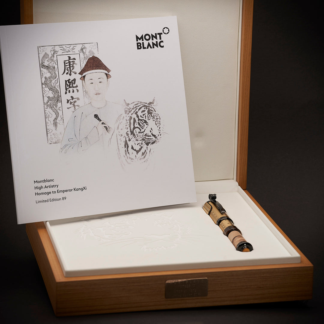 Füller liegt leben aufgestelltem Editionsheft in offener Holzbox vor dunkelgrauem Hintergrund