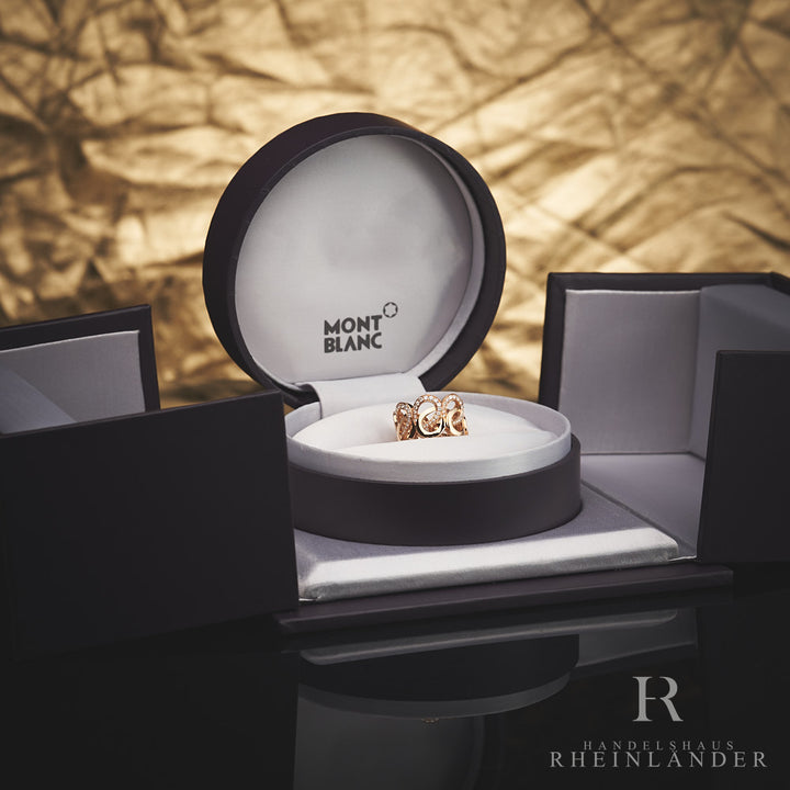 Goldener Ring mit Schleifenstruktur und Diamantbesatz in offener Originalbox vor goldenem Hintergrund