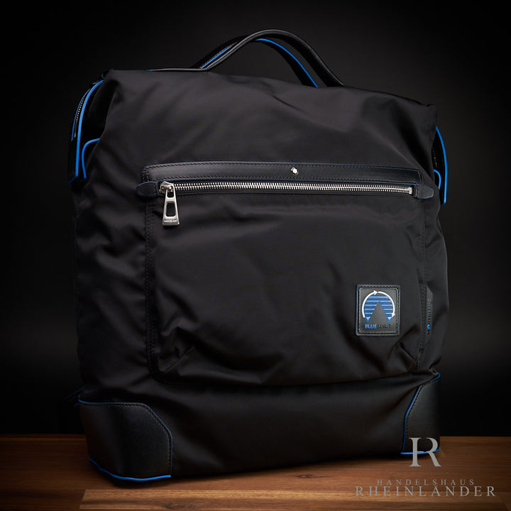 schwarze Montblanc Tasche mit blauen Applikationen und Reißverschluss auf Holztisch
