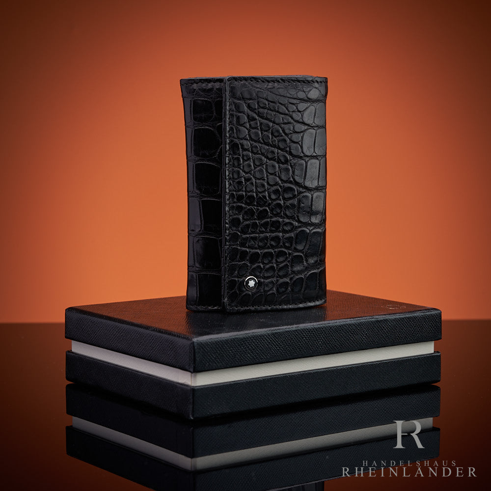 Schlüsseletui aus schwarzem Alligatorleder auf Montblanc-Geschenkbox vor orangem Hintergrund
