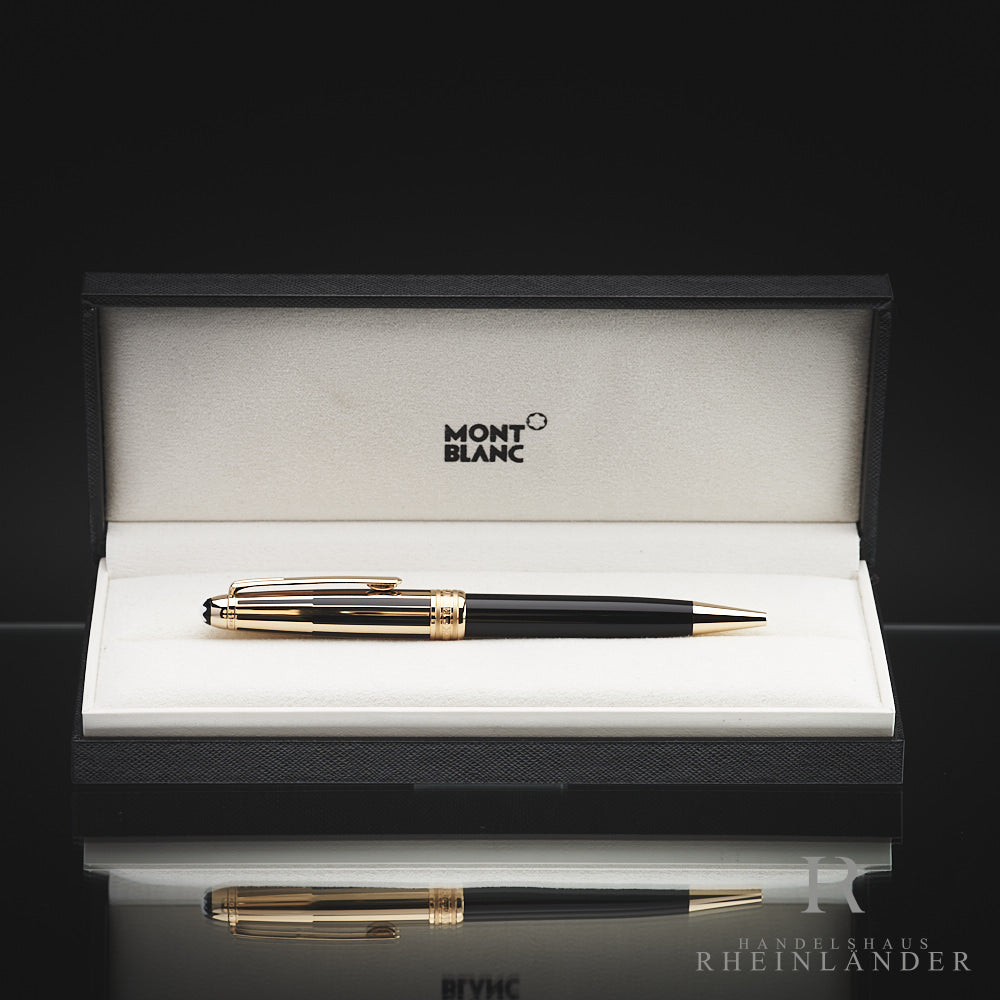 Schwarz-goldener Kugelschreiber von Montblanc, in geöffneter Originalbox liegend vor schwarzem Hintergrund fotografiert