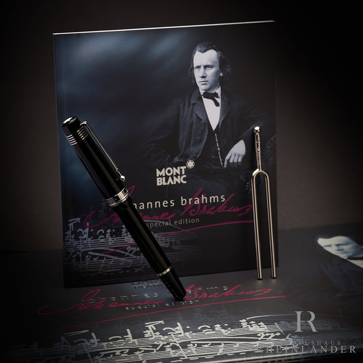 Schwarzer Rollerball von Montblanc mit Serviceguide mit Johannes Brahms-Cover und silberner Stimmgabel fotografiert