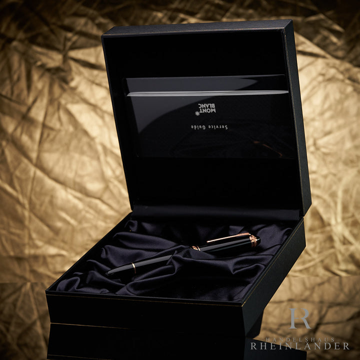 Schwarzer Rollerball in schwarzer Montblanc-Box mit Serviceheft vor goldenem Hintergrund