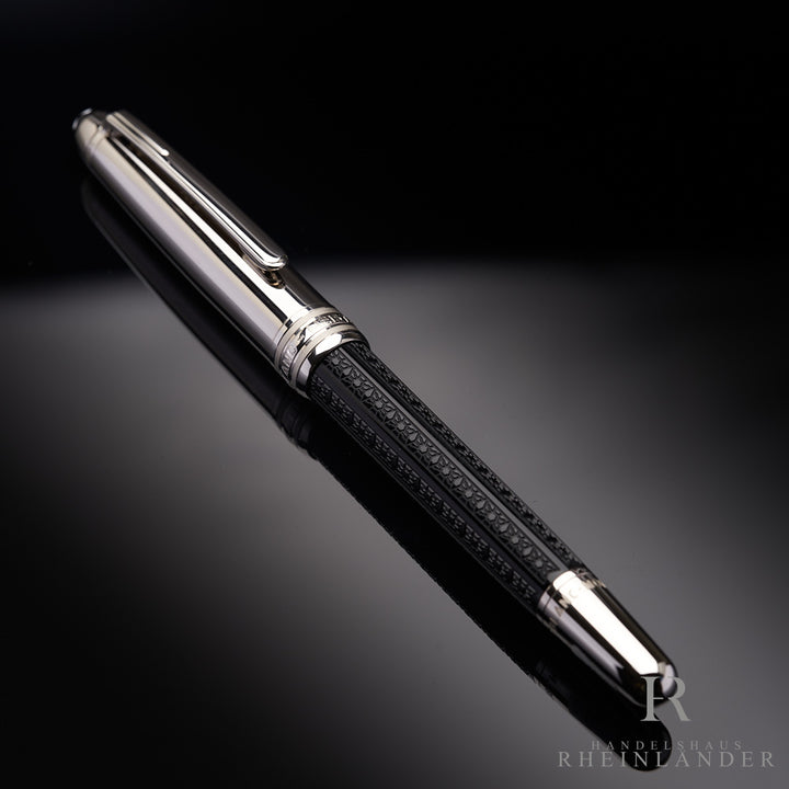 Füllfederhalter mit silbernen Kappe und schwarzem Griffstück liegt geschlossen auf spiegelndem Hintergrund.