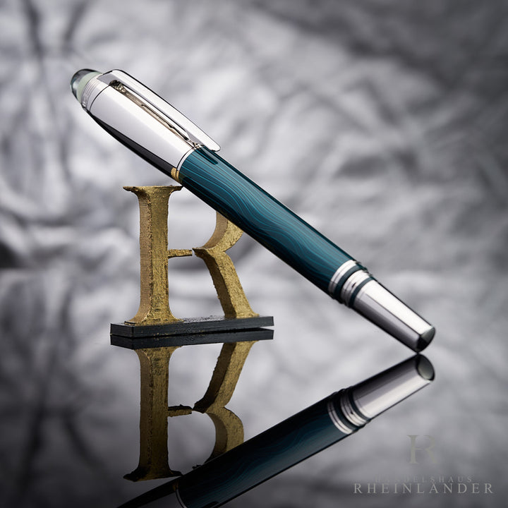 Dunkelgrüner Rollerball von Montblanc mit Wellenmuster und silberner Kappe und Beschlägen vor hellgrauem Hintergrund
