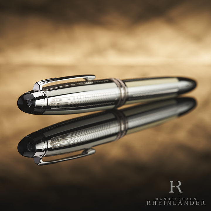 Füller liegt geschlossen auf spiegelndem Untergrund mit Fokus auf die Kappe und den darin eingelassenen Diamanten