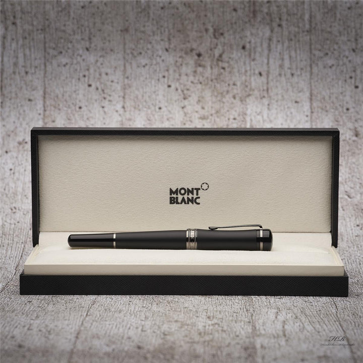 Schwarzer Montblanc Rollerball liegt in offener Originalbox vor grauem Hintergrund in Holzoptik