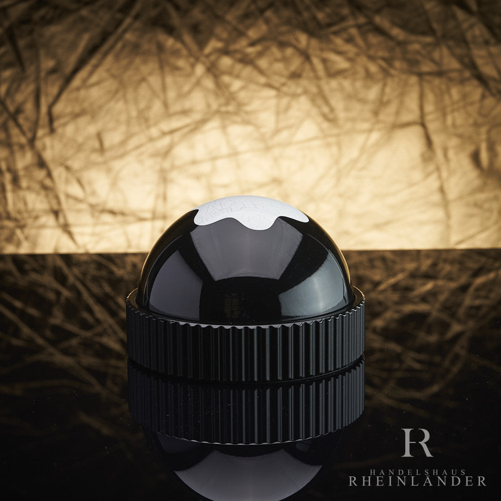 Montblanc Briefbeschwerer aus Glas mit Emblem vor goldenem Hintergrund