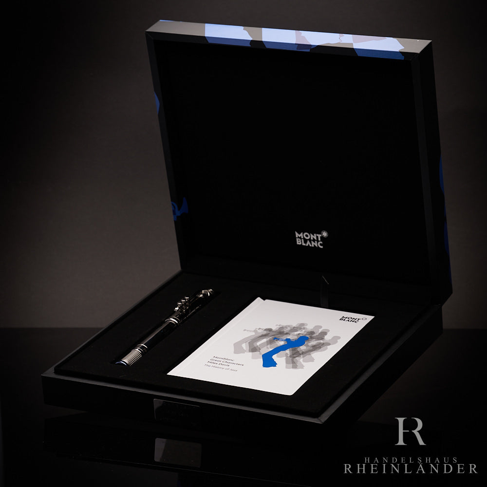 Silberner Füller liegt zusammen mit Serviceguide in offener, schwarzer Originalbox vor dunkelgrauem Hintergrund