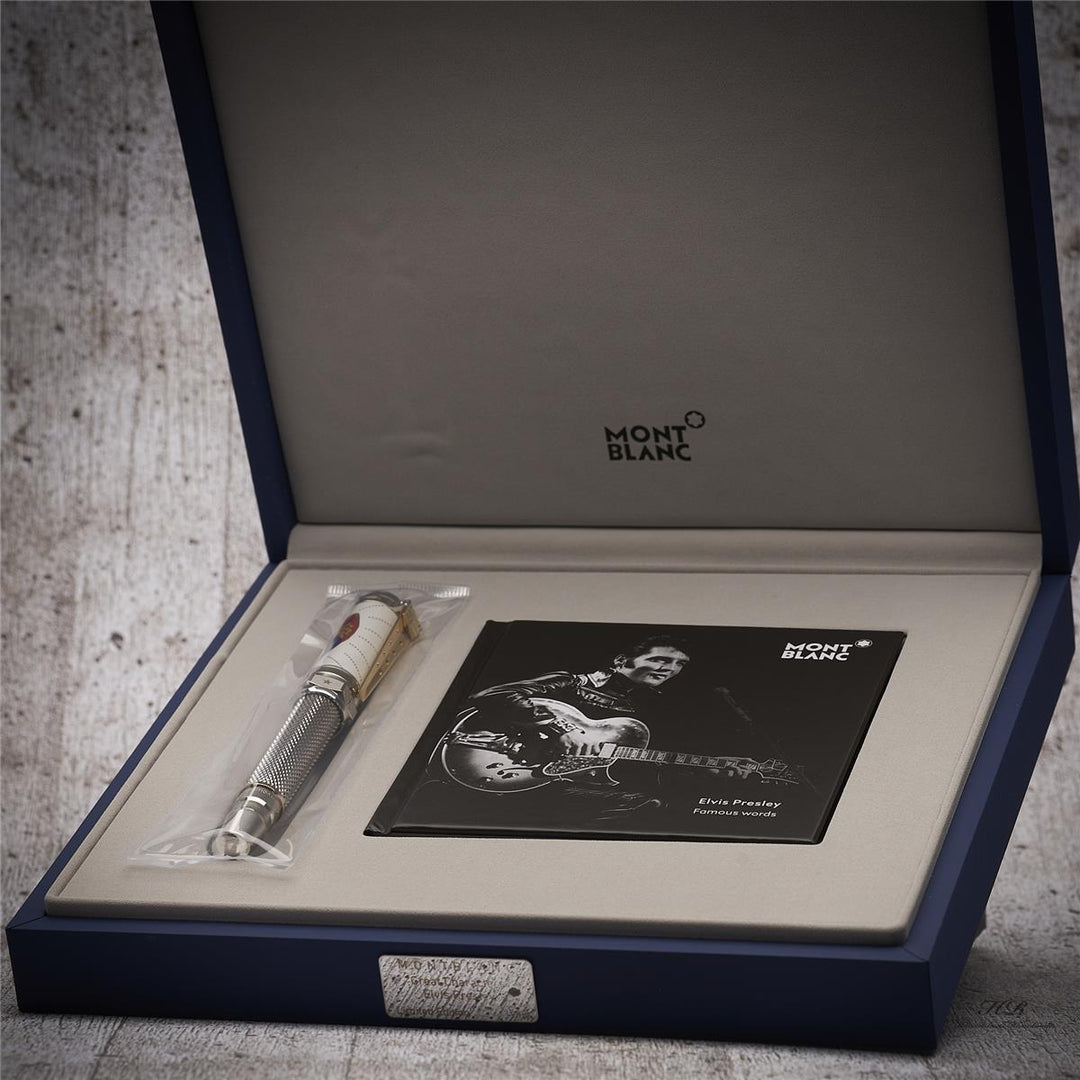 Füller und Elvis-Serviceheft liegen in blau lackierter, offener Editionsbox vor grauem Holzoptik-Hintergrund