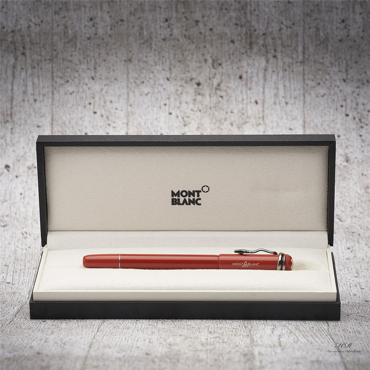 Roter Rollerball liegt in offener Originalbox vor hellgrauem Hintergrund in Holzoptik